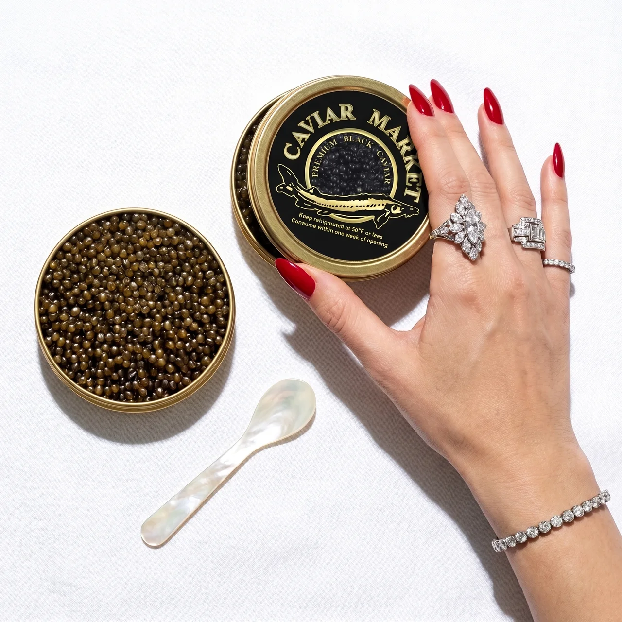Open tin of Kaluga Queen caviar beside a sealed Caviar Market tin and mother-of-pearl spoon